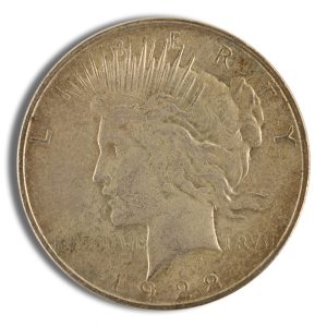 Close-up of a 1922 Peace dollar coin showing Liberty's left-facing profile and sun rays behind her head.